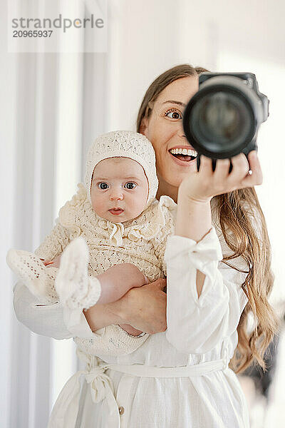 Mother and baby taking a joyful selfie together at home