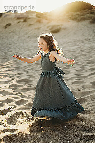 Beautiful Hispanic girl smiling dancing twirling beach sunset summer