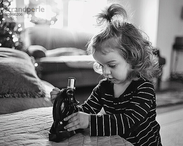 Female toddler using microscope at Christmas