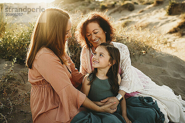 Mother  daughter and grandma together at beach smiling holding hands