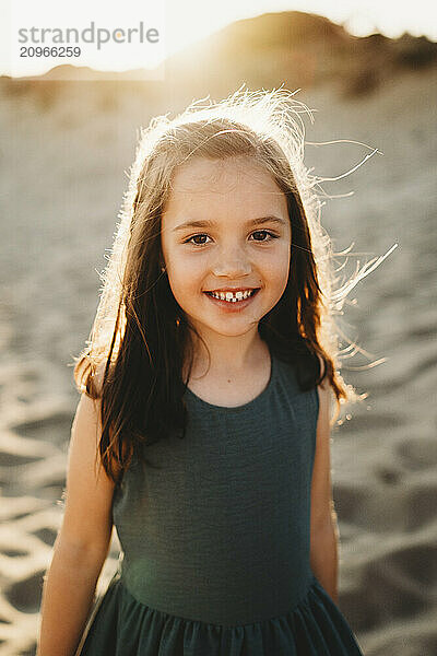 Portrait of beautiful Spanish girl smiling at beach sunset summer