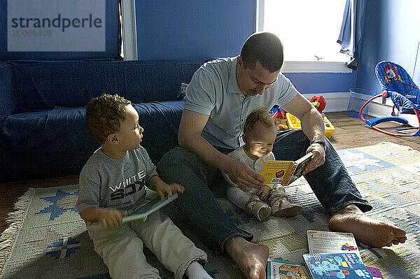 A father reads to his son and daughter