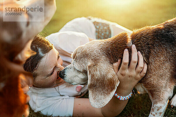 Girl playing with dogs in backyard with golden light