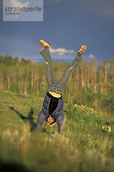 Young woman doing handstands while camping in Grand Teton National Park  WY.