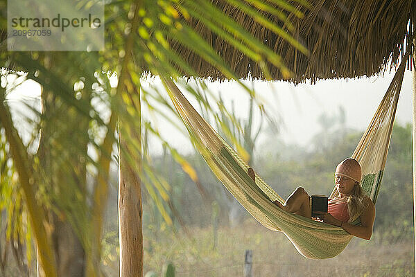 Young woman relaxing in hammock in Mexico.