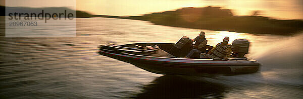 Two guys speeding past in a high-powered bass boat.