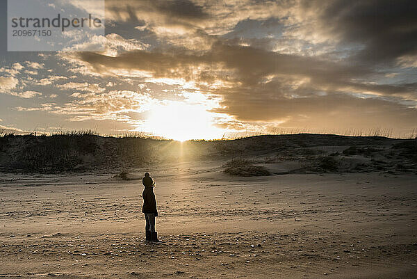 Young girl knit hat standing on windy beach Cape Hatteras