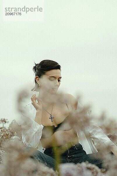 Young woman sitting peacefully in a field