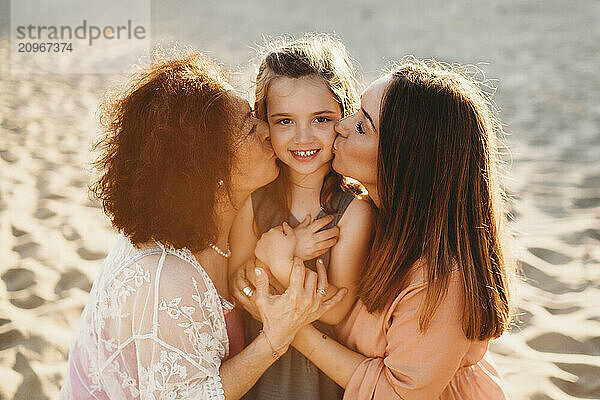 Portrait three generations beautiful Spanish women at beach kissing