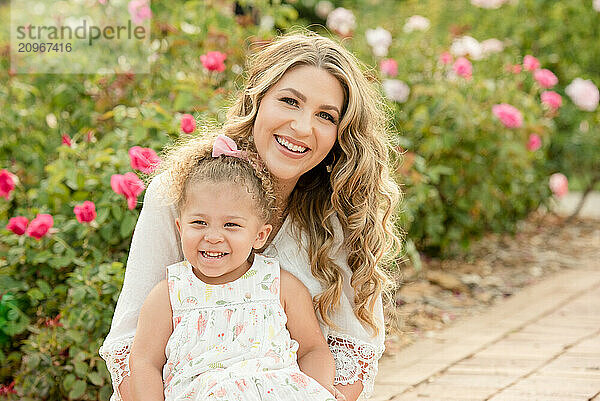 Mother and daughter smiling in garden