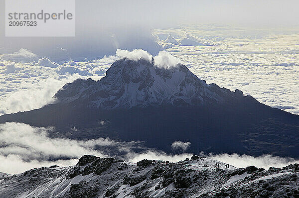 Climbers ascending the crater rim of Mt. Kilimanjaro  the highest mountain in Africa  with Mawenzie Peak behind.