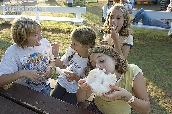 Girls enjoying maple sugar cotton candy at the Fryeburg Fair in Maine.