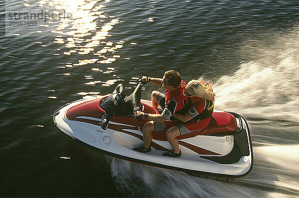 Twenty-year-old couple enjoying a ride on their jet ski.