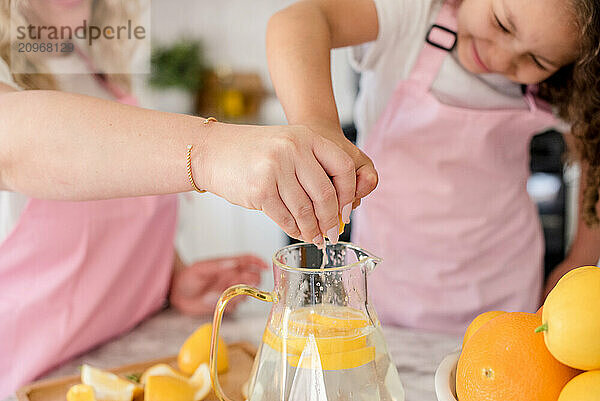 Close up of mother and daughters hands squeezing lemons