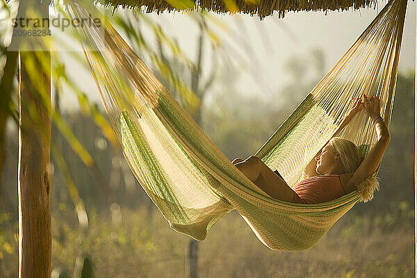 Young woman relaxing in hammock in Mexico.