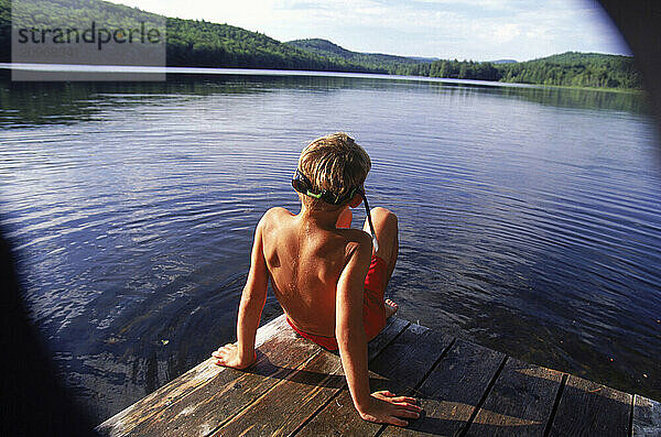 Portrait of young boy on the dock of Heald Pond  Maine.