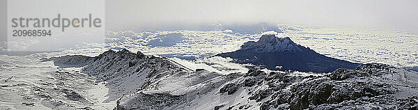 Climbers ascending the crater rim of Mt. Kilimanjaro  the highest mountain in Africa  with Mawenzie Peak behind.