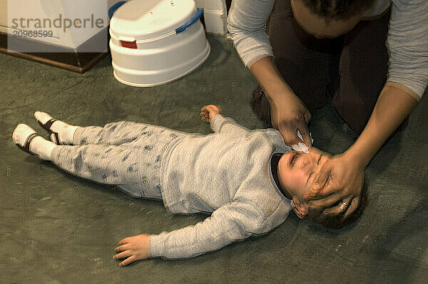 A boy is cleaned up by his mother after dinner