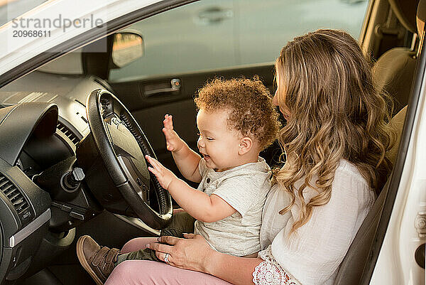 Mother and son sitting in drivers seat of car