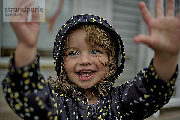 Beautiful toddler in raincoat blue eyes blonde curls