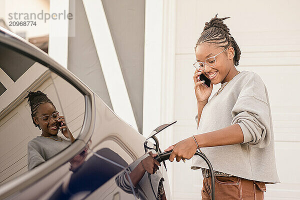 Young lady on phone plugging in car charger