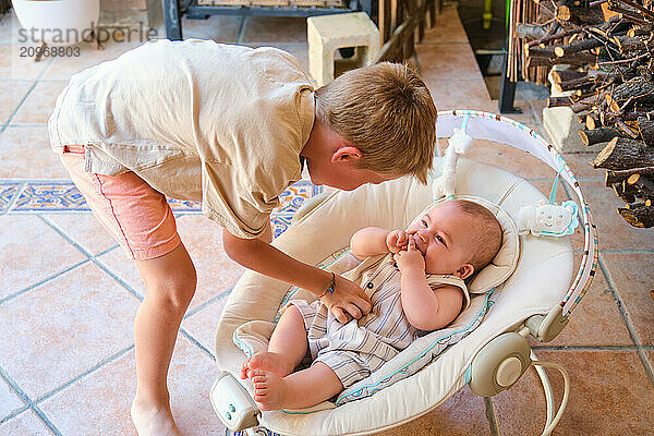 Older brother taking care of baby brother at home