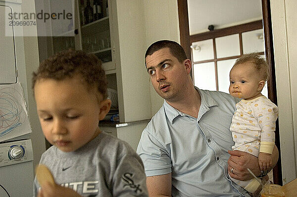 A young family sits in the kitchen