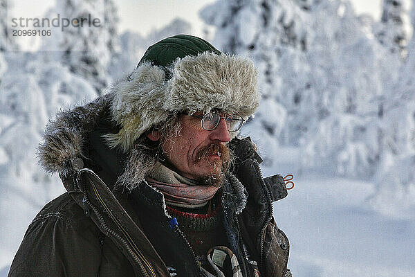 Dogsled guide gazes into the wintry wilderness