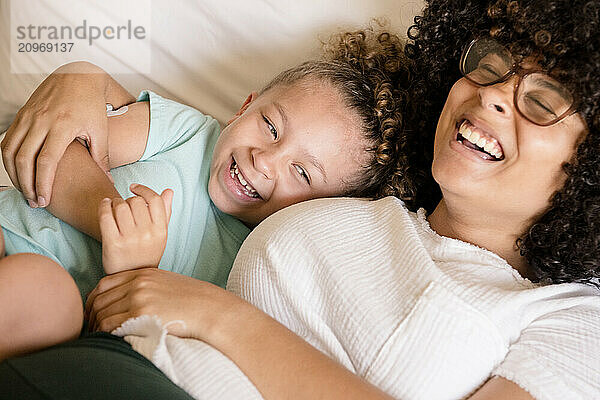 Sisters laughing together on bed