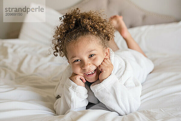 Little girl is laying down on her stomach