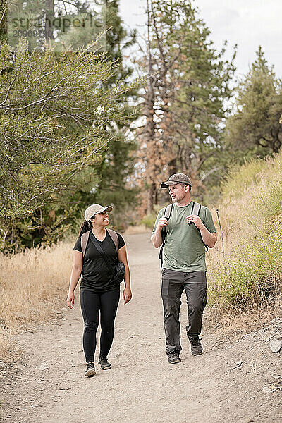 Front shot of couple walking together outdoors smiling