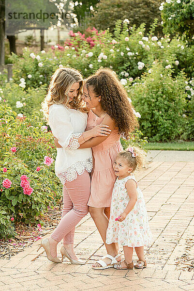 Mother laughing with daughters in garden