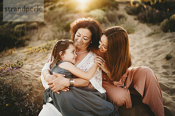 Mother daughter grandma together beach smiling holding hands happy