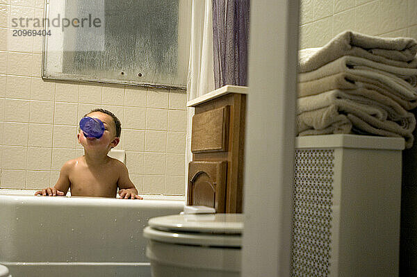 A boy plays in the bath tub