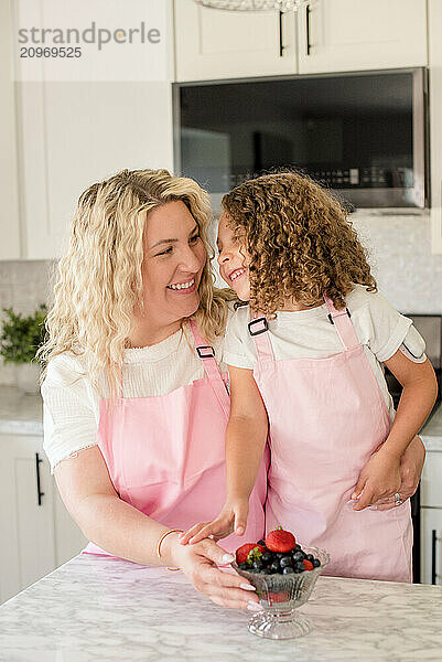 Mother holding daughter with diabetes in the kitchen