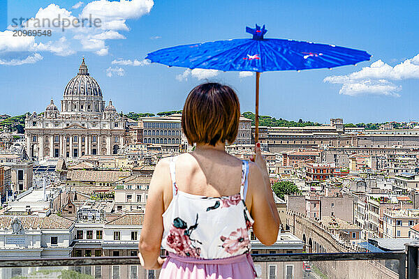 Woman with umbrella looking at Vatican City from Castel Sant'Angelo