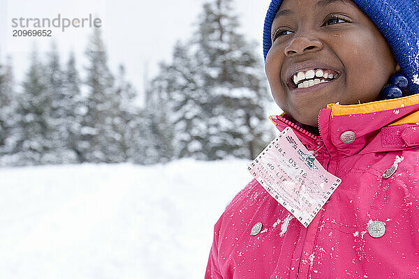 Young girl in a pink jacket playing in snow at Kirkwood ski resort near Lake Tahoe  California.