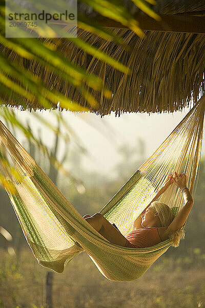 Young woman relaxing in hammock in Mexico.