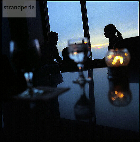 Silhouettes of a couple at an observation deck restaurant