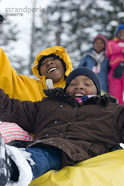 Three young kids riding snowtube at Kirkwood ski resort near Lake Tahoe  California.