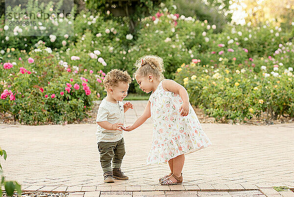 Sister helping brother in the garden