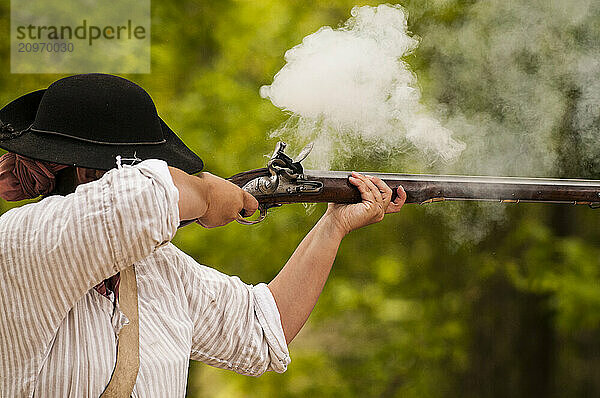 Historical reenactor firing a musket in Jamestown  Virginia.