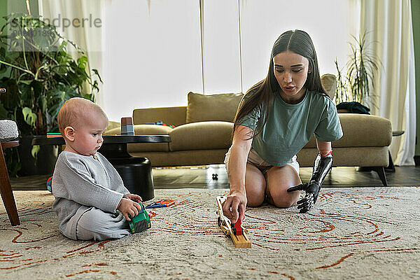 Young woman with prosthesis enjoys playing with baby