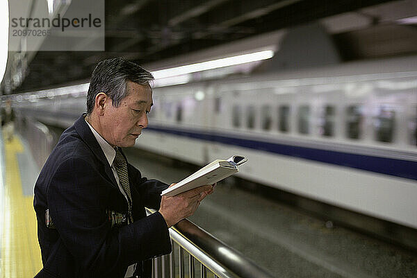 A 'Salary man' or businessman  waits for the Bullet Train or Shinkansen