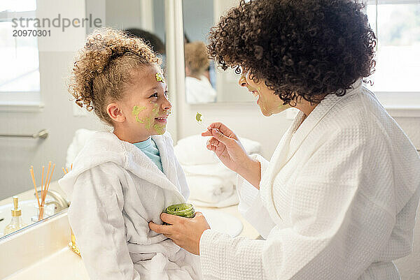 Big sister is putting face mask on little sisters face