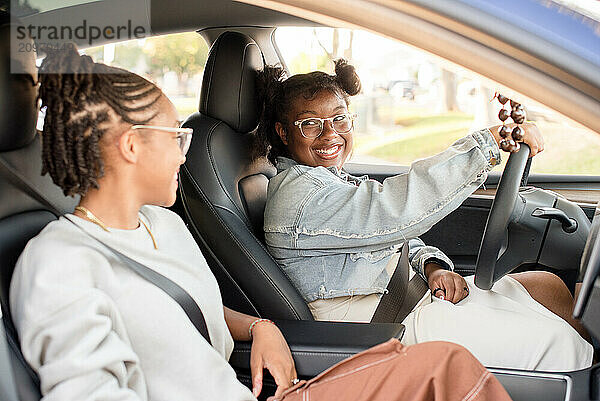 African American friends laughing together while driving