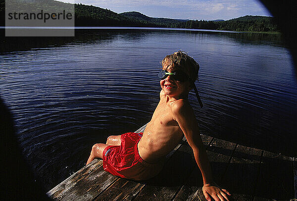 Portrait of young boy on the dock of Heald Pond  Maine.