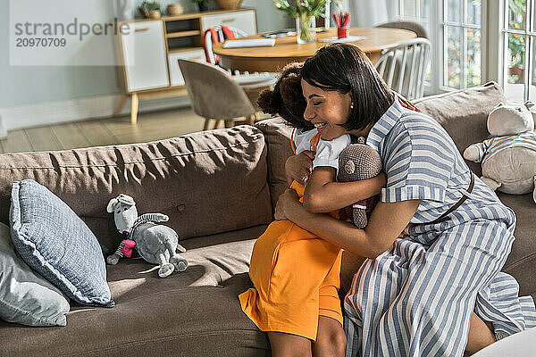 African American woman and daughter hugging tenderly