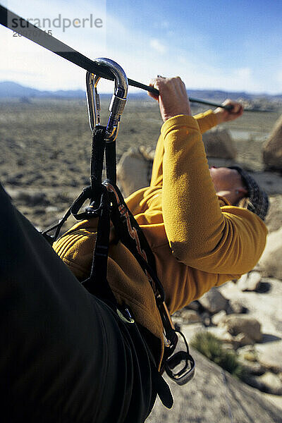 Woman on Tyrolean traverse Joshua Tree National Park  California.