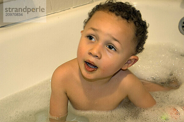 A boy plays in the bath tub